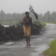 A man struggles with an umbrella in strong winds and rain caused by Cyclone Hudhud in Gopalpur in Ganjam district in Odisha.